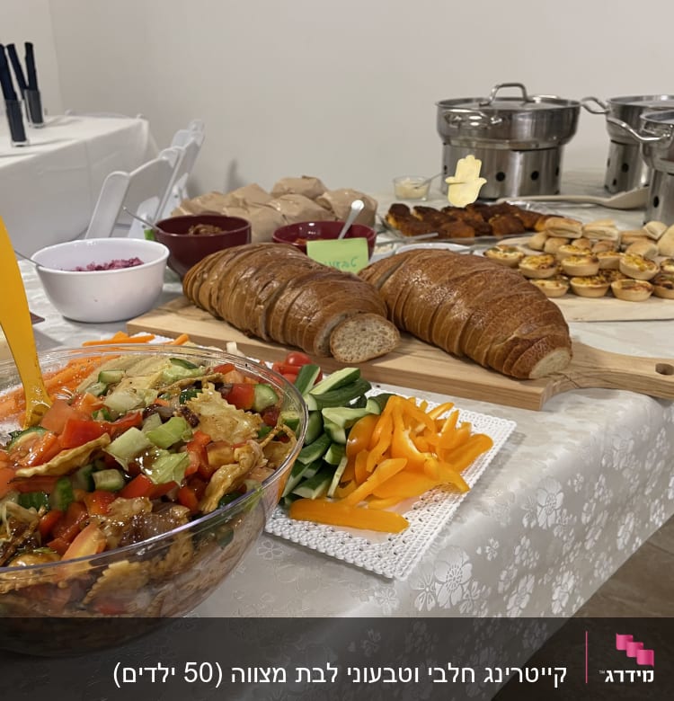 שולחן קייטרינג עם סלט, לחם, ירקות ומאפים